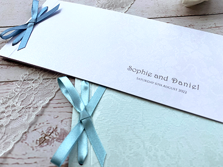 satin bow cheque book wedding invitations showing embossing on covers